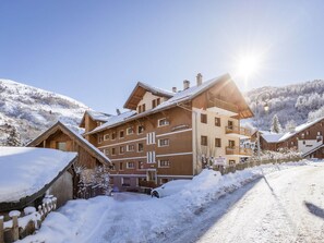 A multi-story hotel with a snow-covered landscape, a clear sky, and a sunny setting. - South view apartment, pets welcome - 4 guests (Valloire)