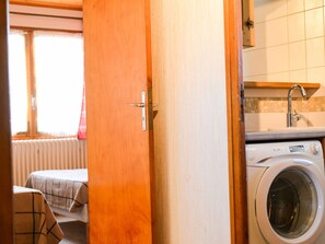 A laundry room with a washing machine, a drying rack, and a window with blinds. - Apartment pet-friendly - 5 guests (Valloire)