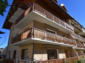 A multi-story building with balconies, a wooden facade, and flower boxes. - Apartment pet-friendly - 5 guests (Valloire)