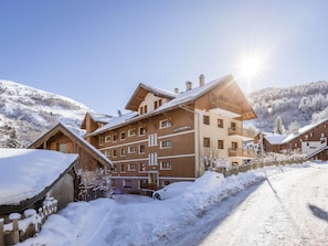 A multi-story hotel with a snow-covered landscape, a clear sky, and a sunny setting. - Apartment pet-friendly - 5 guests (Valloire)