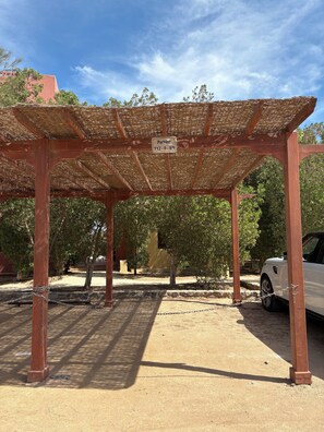 A covered parking area with a sign indicating parking restrictions. - 2BR Apartment in West Golf, El Gouna (Red Sea Governorate)