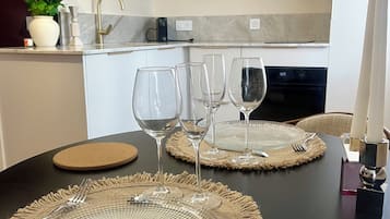 Ein Esstisch, gedeckt mit klarem Glas, einem Messer und einem Kerzenhalter.