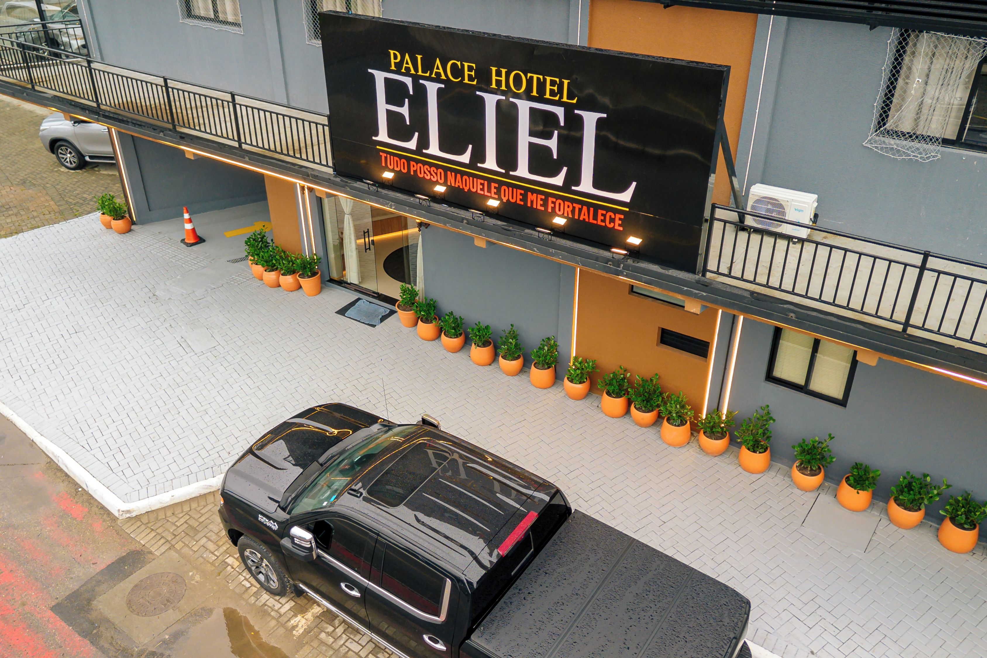 Hotel 'Palace Hotel Eliel' met een zwarte auto ervoor geparkeerd.