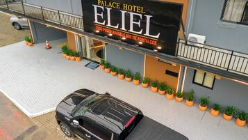 Hotel 'Palace Hotel Eliel' met een zwarte auto ervoor geparkeerd.
