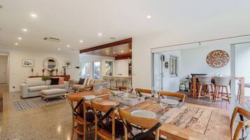 A spacious living area with a dining table set for six, surrounded by comfortable seating.