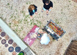 An outdoor area with a barbecue grill, a paved walkway, and a decorative metal fence. - Ocean Breeze Boutique Hotel (Nungwi)