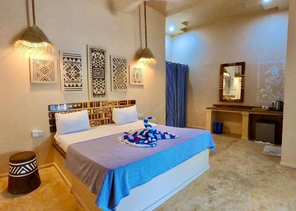 Una habitación de hotel con cama, mesita de noche y espejo.