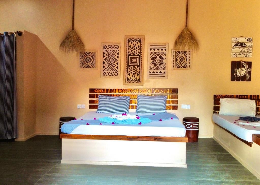 Una habitación con una cama, mesitas de noche, una pared con paneles decorativos y una cortina.