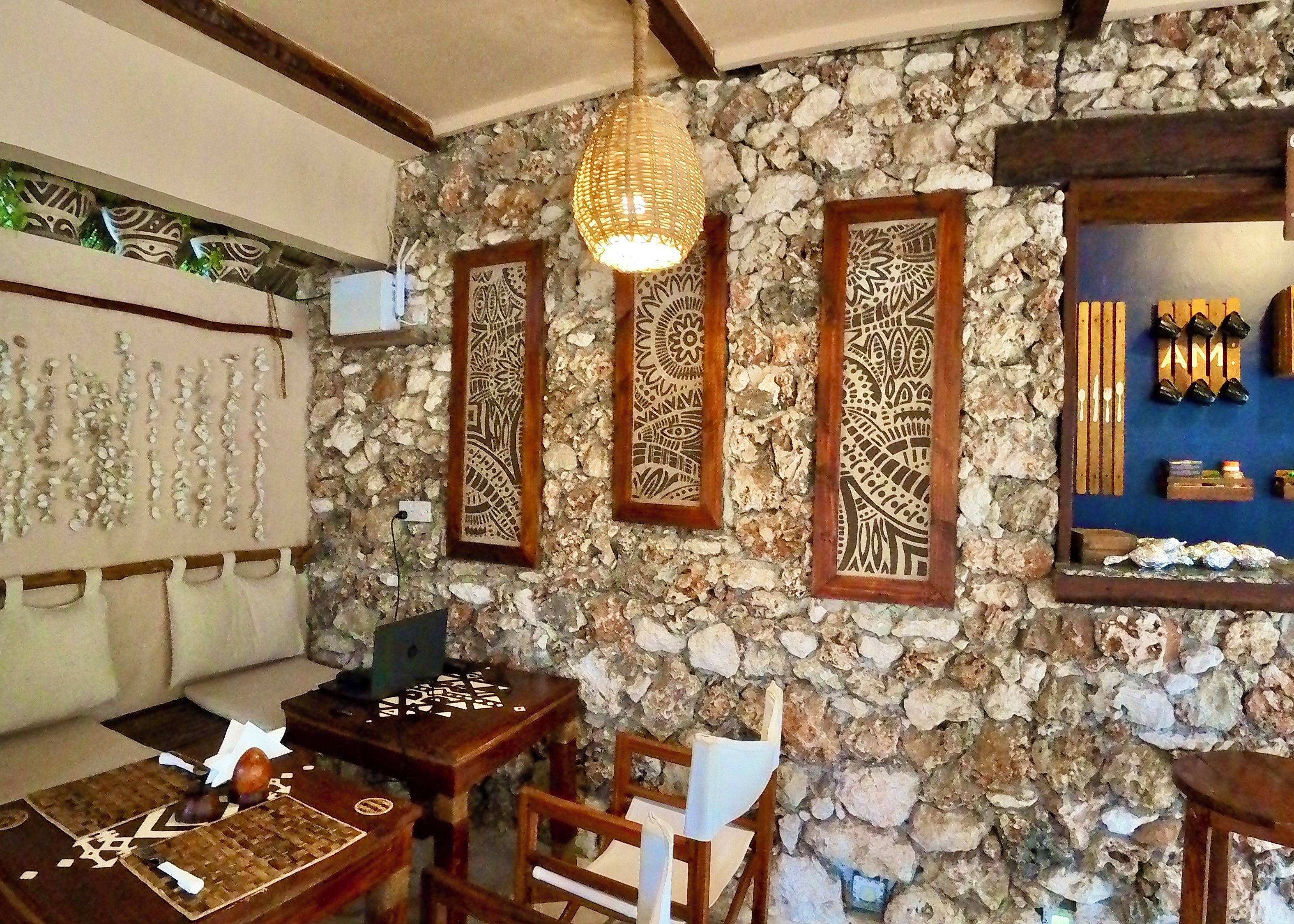 Una habitación con pared de piedra, muebles de madera y detalles decorativos.