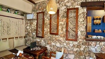 Una habitación con pared de piedra, muebles de madera y detalles decorativos.