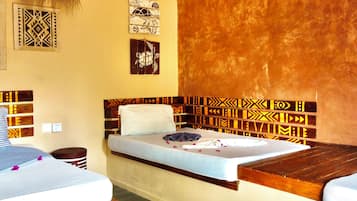 Una habitación con cama, mesita de noche, un reloj en la pared y decoración mural.