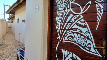 Una puerta de madera con elaborados adornos blancos, una pared color beige y una reja de metal.