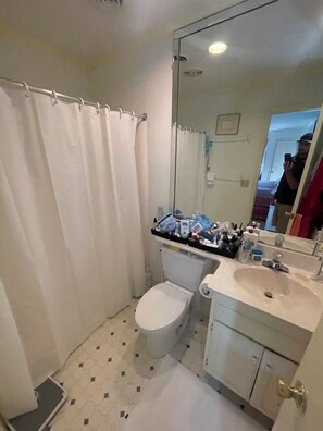 A small bathroom with a toilet, a sink, and a shower curtain. - The Scotch Bonnett Beach House - Best Location! (Nags Head)