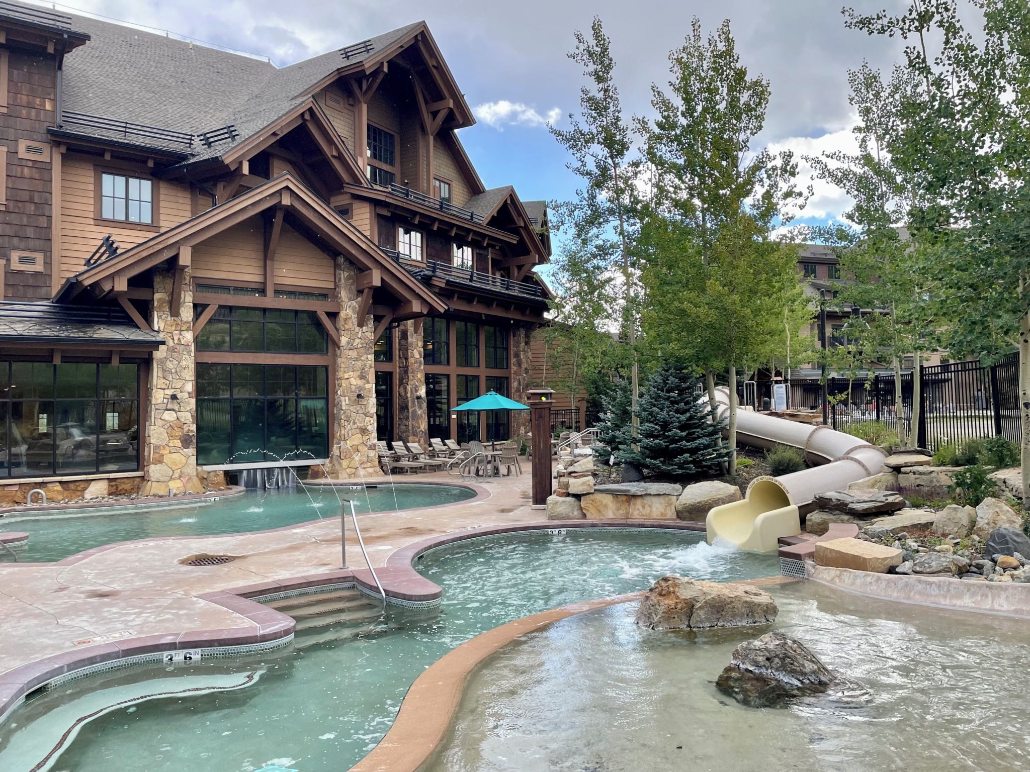 Un albergue con zona de piscina, que incluye un jacuzzi y un tobogán de agua.