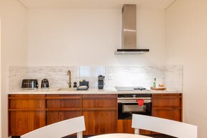 A compact kitchen with a built-in oven, a coffee machine, and a microwave. - Premium Studio Suite - Vila Catarina Luxury Apartments (Porto)