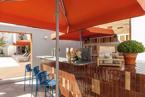An outdoor bar area with a counter, blue chairs, and a menu board. - Premium Studio Suite - Vila Catarina Luxury Apartments (Porto)