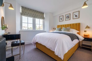 A neatly arranged bedroom with a large bed, bedside tables, a desk, and a window with a view. - Luxury Loft Above The Chipping Steps, Tetbury  (Tetbury)
