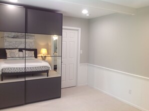 A bedroom with a bed, bedside table, lamp, and a wardrobe. - Your Peaceful Durham Getaway – Near Duke, UNC & RTP (Durham)