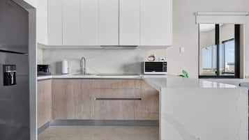 Una cocina moderna con un refrigerador integrado, un microondas y una cafetera.