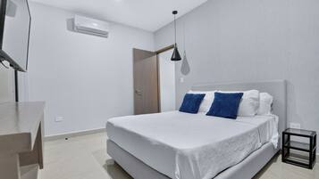 Un dormitorio moderno con cama, mesita de noche y lámpara colgante.
