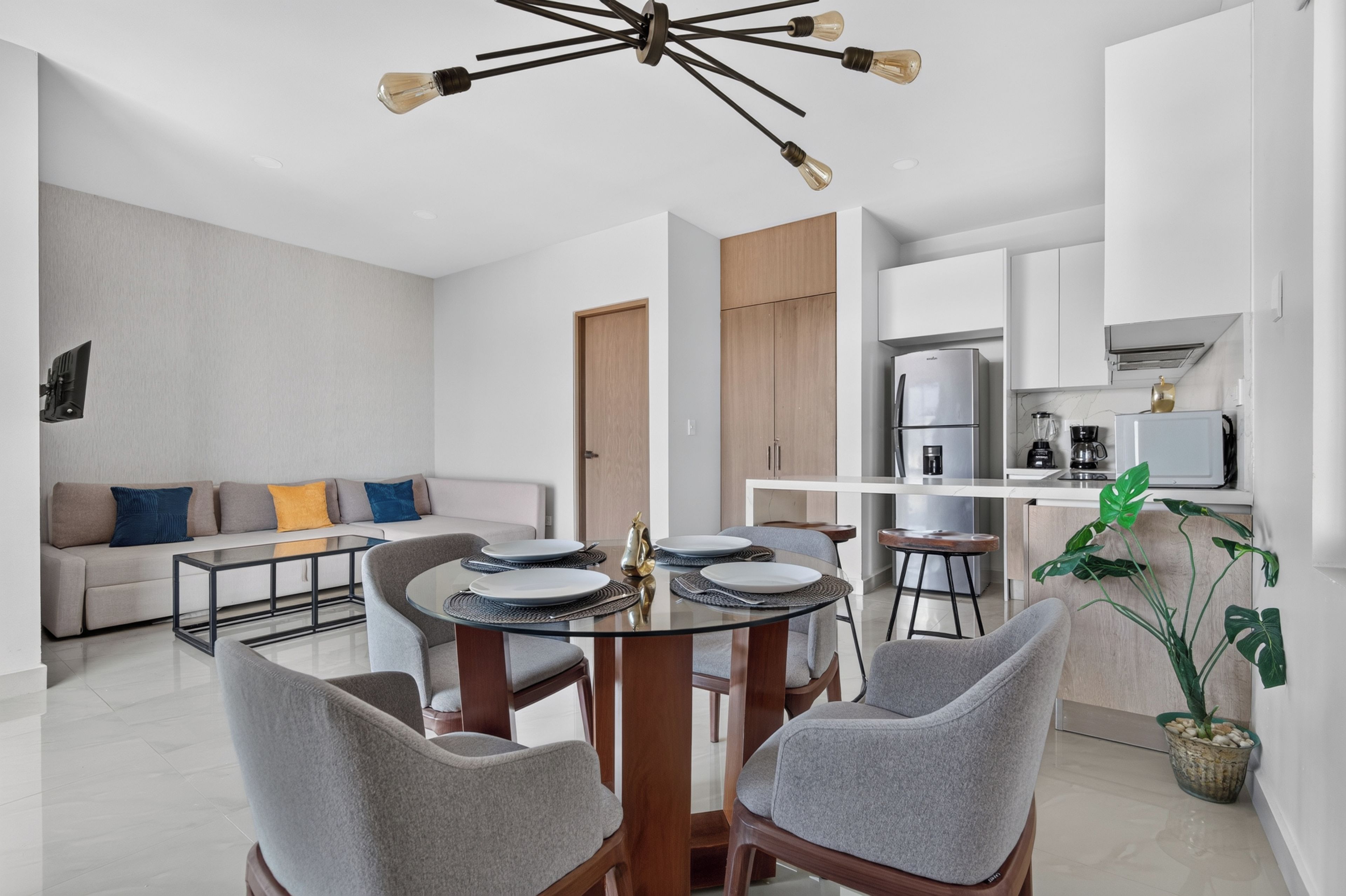 Una sala moderna con comedor, cocina y armario empotrado.