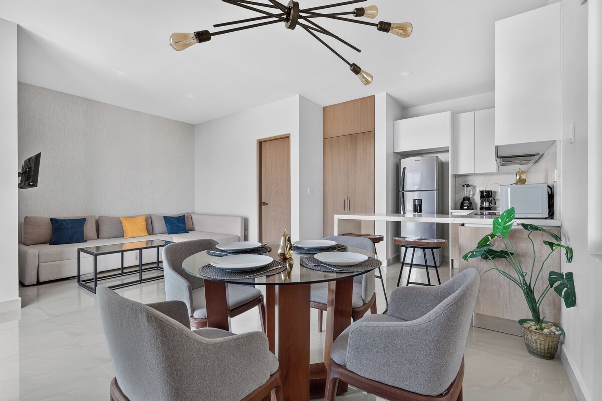Uma sala de estar moderna com área de refeições, cozinha e um guarda-roupa embutido.