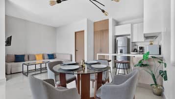 Una sala moderna con comedor, cocina y armario empotrado.