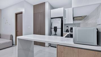 Una cocina moderna con encimera de mármol, electrodomésticos integrados y un armario de madera.