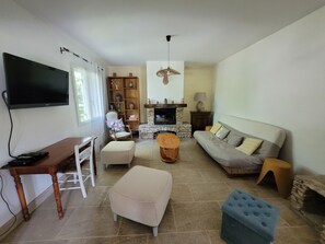 A living room with a television, seating area, fireplace, and a bookshelf. - House with a yard in a quiet neighborhood (Entraigues-sur-la-Sorgue)
