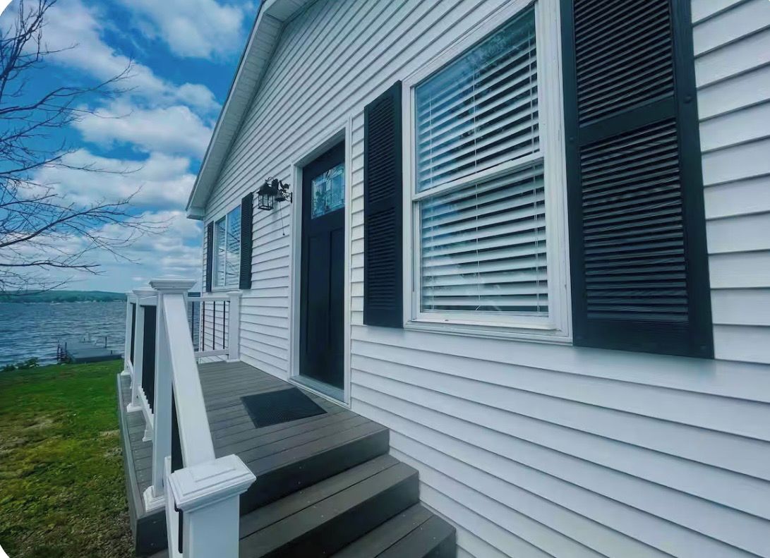 A house with a front porch, a door, and a window with shutters.