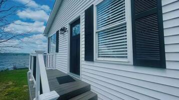 A house with a front porch, a door, and a window with shutters.