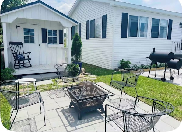 A patio area with outdoor furniture, a fire pit, and a barbecue grill.