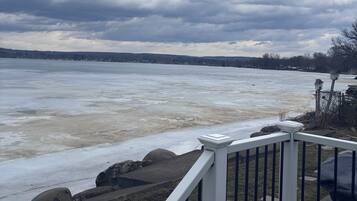 A view of a frozen river with a railing in the foreground.
