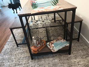 A wooden table with a decorative table runner, a glassware holder, and a tray with a cocktail shaker and other items. - RELAX FISHING & EXPLORE WATERFRON GATAWAY RETREAT WITH A PRIVATE DOCK &BOAT LIFT (Punta Gorda)