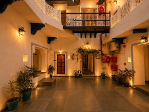 A courtyard with a central staircase, potted plants, and a balcony with ornate railings. - Hari Priya Resort Udaipur (Udaipur)