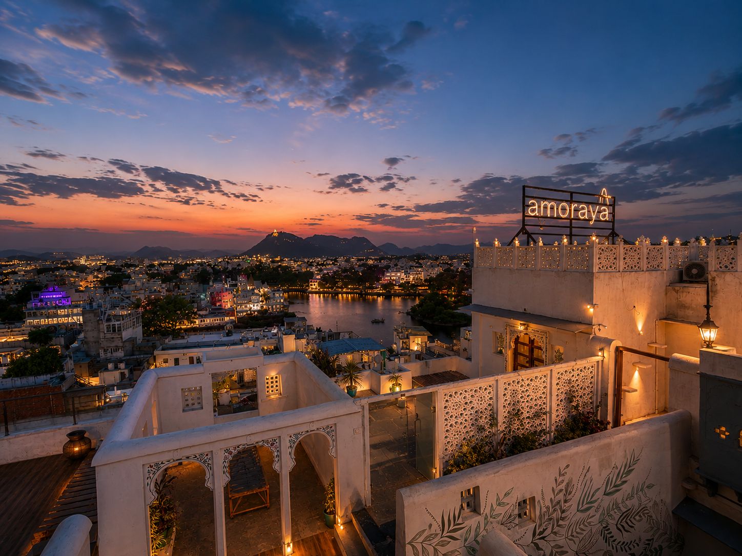 A hotel with a view of a cityscape and a river at dusk.