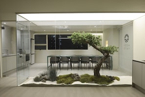 A modern meeting room with a glass partition, a wooden table, and chairs. - VODASTAY 2-3 (Busan)