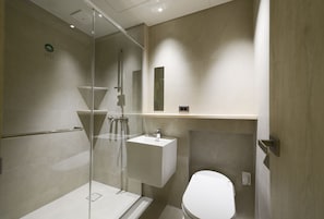 A modern bathroom with a glass-enclosed shower, a white sink, and a toilet. - VODASTAY 2-3 (Busan)