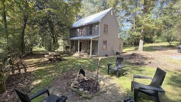 A house with a porch, a fire pit, and outdoor seating.
