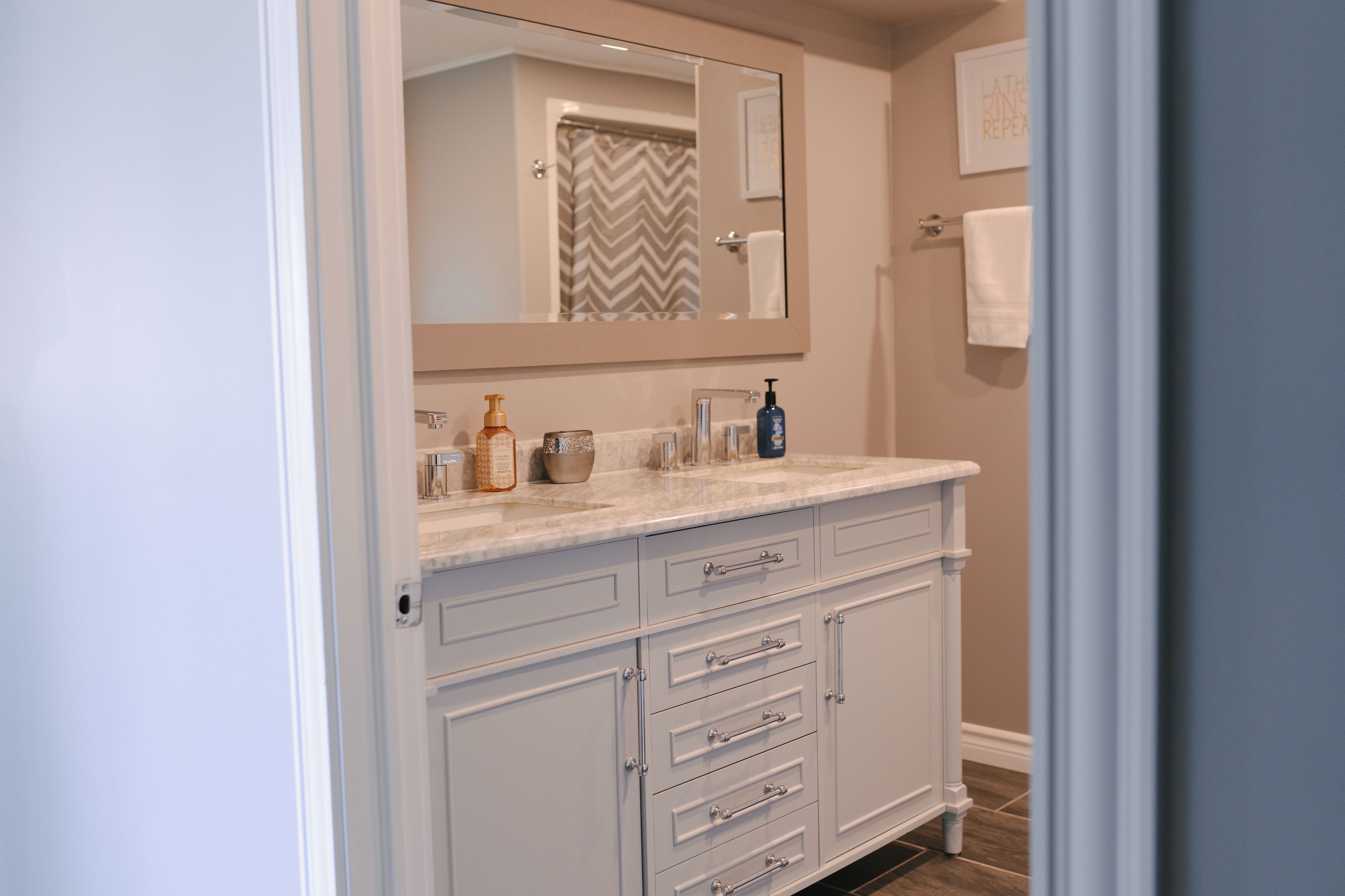 Une salle de bain avec un meuble-lavabo blanc, un miroir et un rideau de douche.