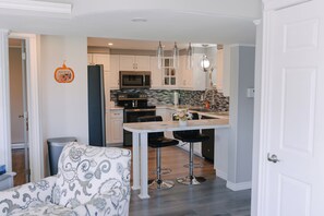 A modern kitchen with a central island, stainless steel appliances, and pendant lighting.