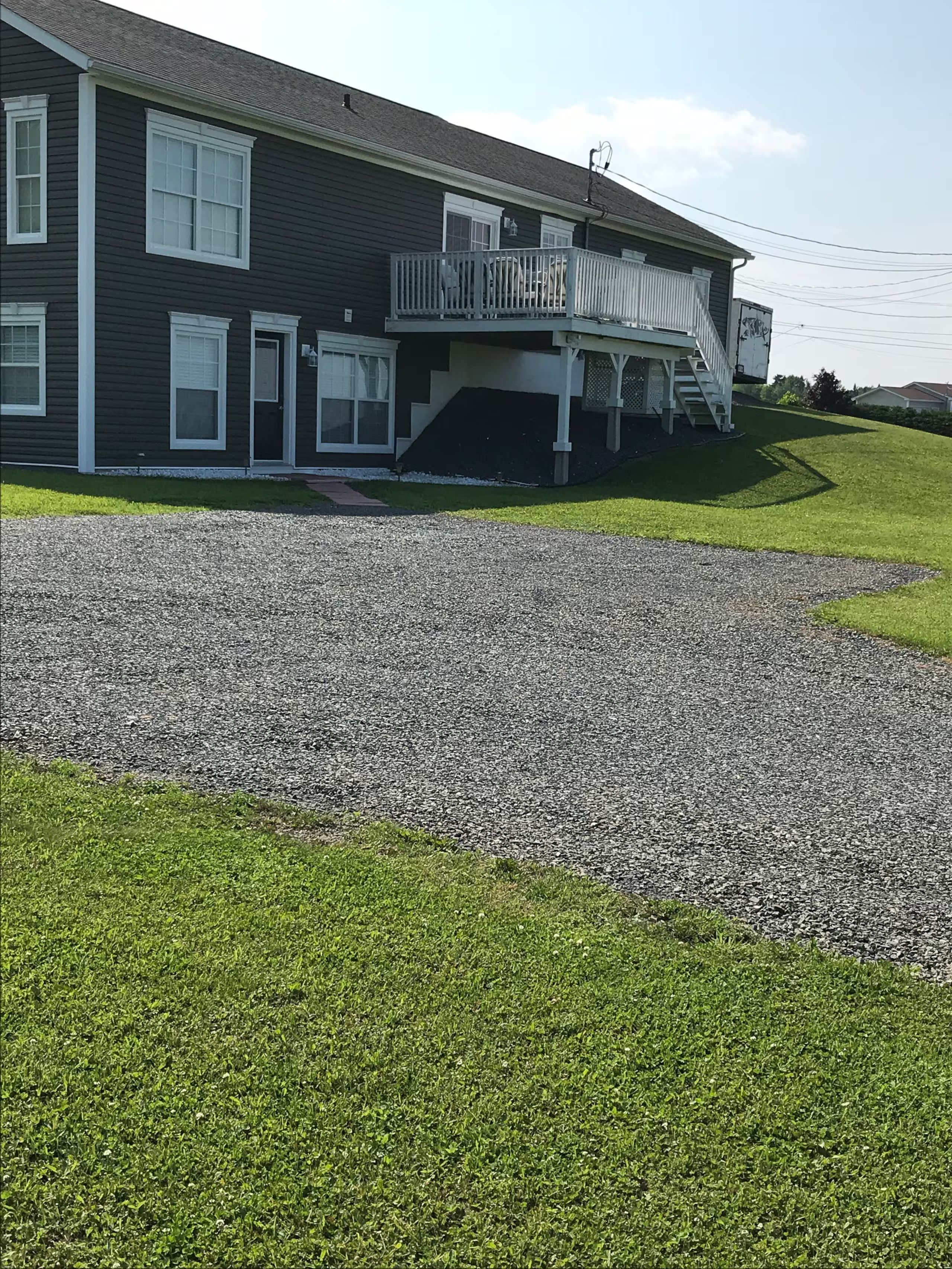 A two-story house with a front porch, a driveway, and a well-maintained lawn.