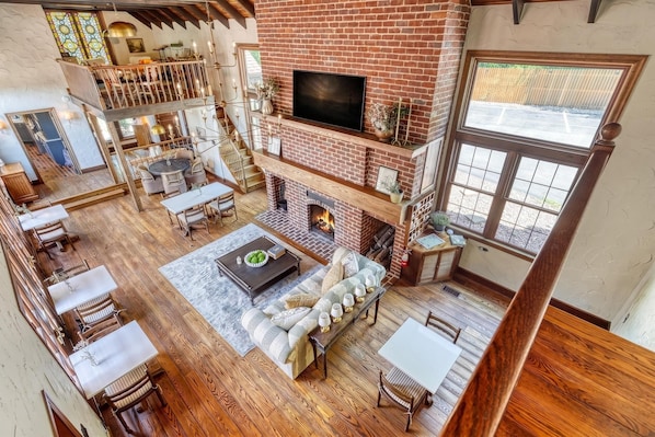 A spacious living area with a fireplace, seating, and a TV.