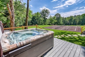 A hot tub on a wooden deck with a basketball court in the background. - Gettysburg Queen Suite for 4 - Fireplace, Sofa Bed, Hot Tub & Sauna (Gettysburg)