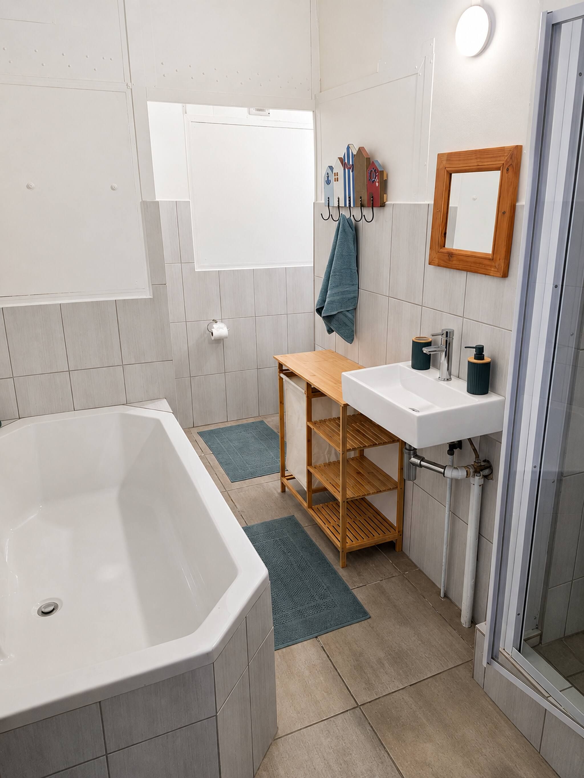 Un baño moderno con bañera, lavamanos y zona de ducha.