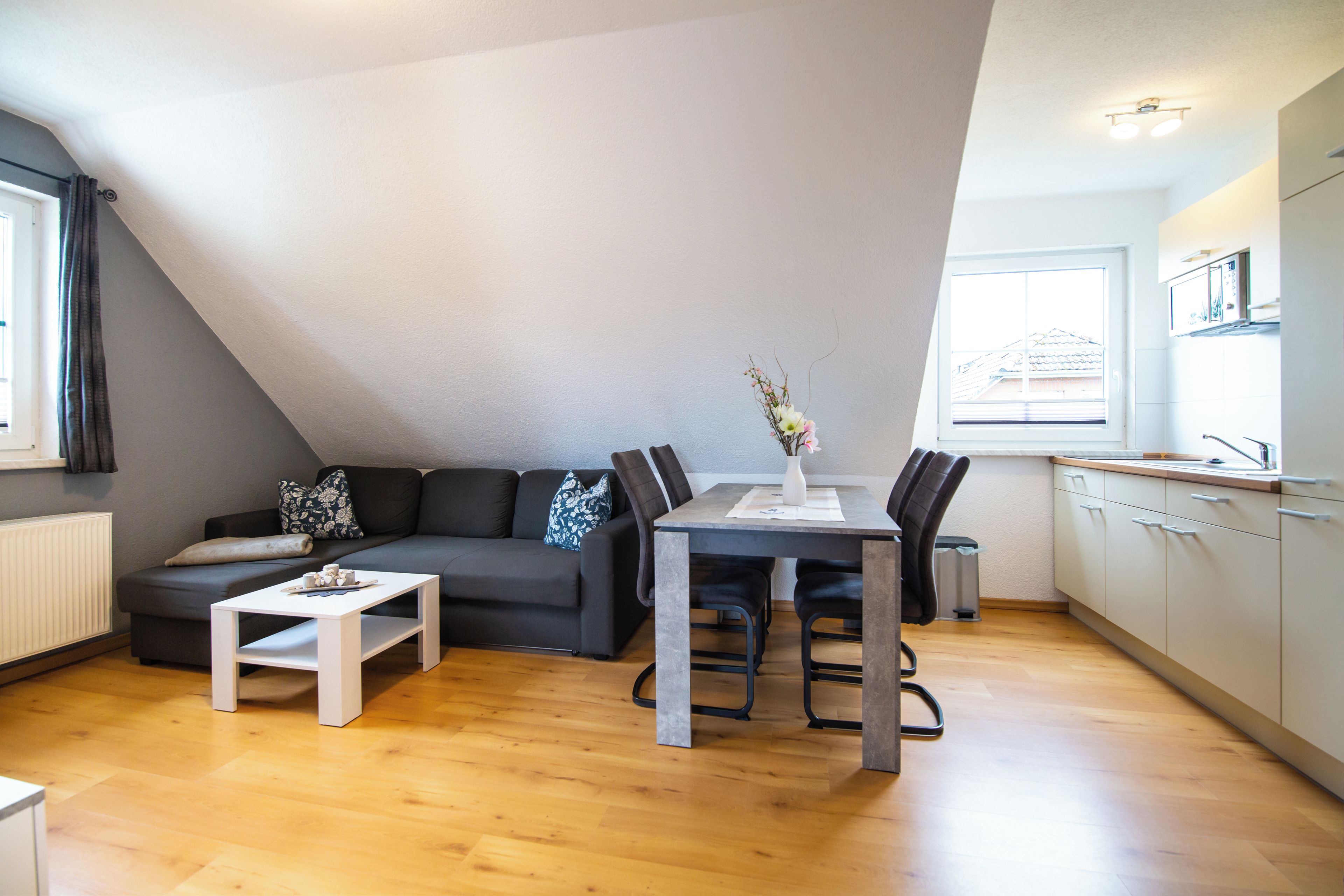 A modern apartment with a loft-style living area, a dining table, and a kitchen.