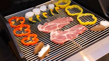 Uma churrasqueira com diversos tipos de carne e legumes.