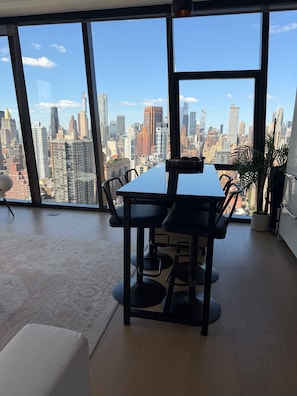 A modern office space with a large window overlooking a city skyline. - Prime Manhattan 2BR, 2BA apt with gym, great amenities & unbeatable location. (New York)