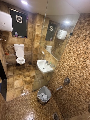 A bathroom with a toilet, sink, and mirror.