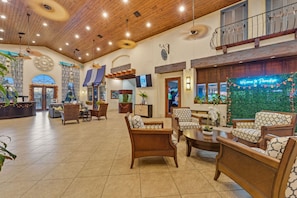 A spacious lobby with wooden ceiling, comfortable seating, a reception desk, and a decorative wall with a welcome sign. - Family 4BR, Private Pool, Resort Amenities (Four Corners)